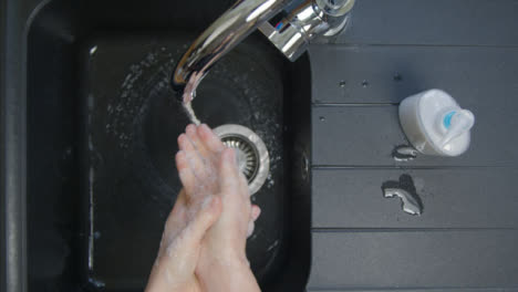 Top-Down-Shot-of-Female-Hands-Rinsing-Soap-from-Hands-Under-Running-Tap