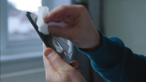 Sliding-Close-Up-Shot-of-Male-Hands-Cleaning-Phone-Screen-with-Anti-Bacterial-Wipe