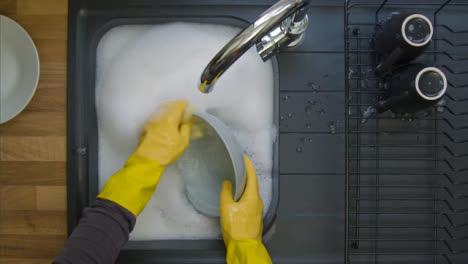 Top-Down-Shot-of-Male-Hands-Washing-Dirty-Plates-In-Soapy-Water