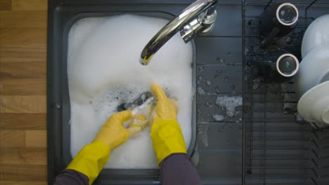 Top-Down-Shot-of-Male-Hands-Washing-Dirty-Glass-In-Soapy-Water