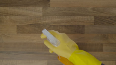 Top-Down-Shot-of-Male-Hands-Cleaning-a-Table-Surface-with-Anti-Bacterial-Spray-and-Cloth