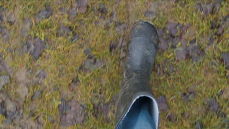 Pov-Erschossen-Mit-Blick-Auf-Stiefel,-Die-Auf-Schlammigen-Fußweg-Gehen