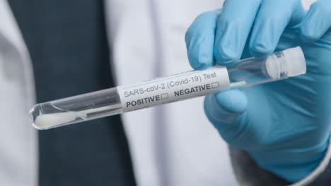 Close-Up-Shot-of-Medical-Professionals-Hand-Holding-COVID-Test-Tube-