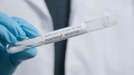 Close-Up-Shot-of-Medical-Professionals-Hand-Holding-COVID-Positive-Test-Tube-
