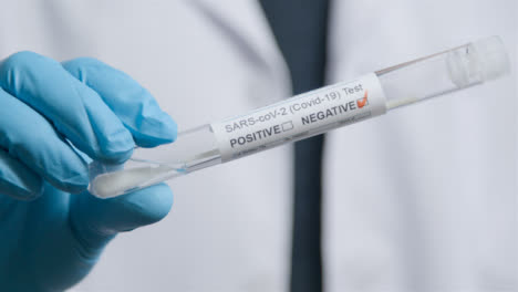 Close-Up-Shot-of-Medical-Professionals-Hand-Holding-Negative-Result-COVID-Test-Tube-