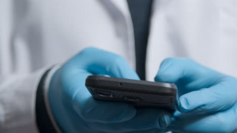 Close-Up-Shot-of-Medical-Professionals-Hands-Using-a-Smartphone-