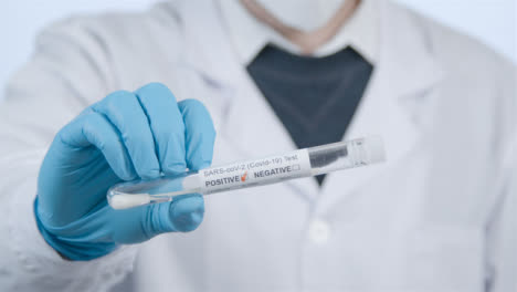 Close-Up-Shot-of-Medical-Professionals-Hand-Holding-a-Positive-COVID-Test-Tube-Result-