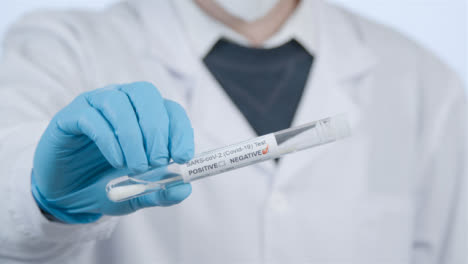 Close-Up-Shot-of-médico-Professionals-Hand-Holding-a-Negative-COVID-Test-Tube-Result