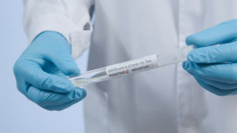 Close-Up-Shot-of-Medical-Professionals-Hands-Holding-a-COVID-Test-Tube-with-Positive-Result