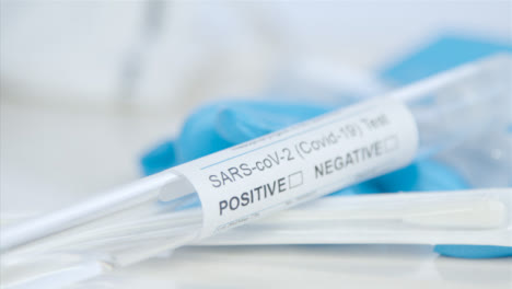 Sliding-Close-Up-Shot-Approaching-a-COVID-Test-Tube-and-Swab