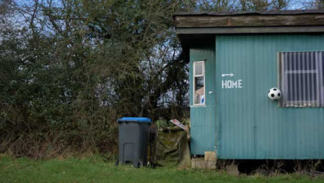 Wide-Shot-of-Soccer-Ball-Bouncing-Off-of-Metal-Cabin-Home-Dressing-Room