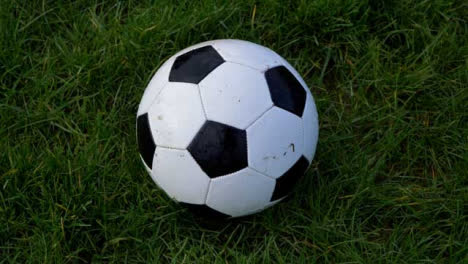 Handheld-Close-Up-Shot-of-Soccer-Ball-On-Grass