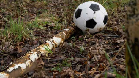 Medium-Shot-of-Soccer-Ball-Landing-Next-to-Rusted-Goal-Post-Laying-On-Floor