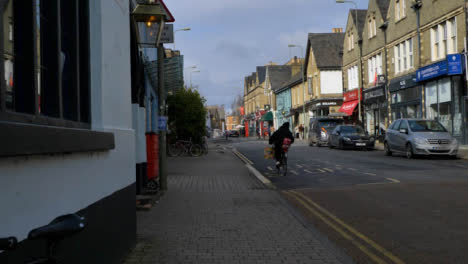 Tracking-Shot-of-Cyclist-Riding-Down-Street