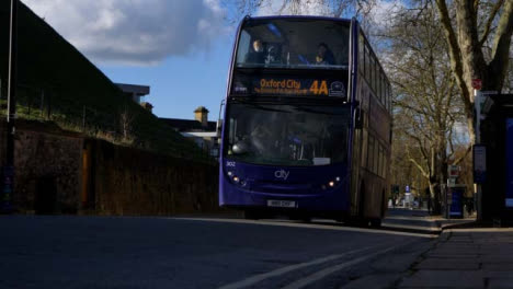 Low-Angle-Shot-of-Buses-Driving-Up-Street-