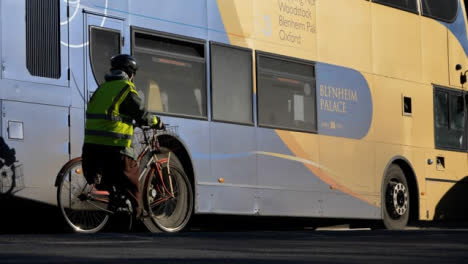 Flachwinkelaufnahme-Eines-Radfahrers,-Der-An-Einem-Geparkten-Bus-Vorbeifährt?