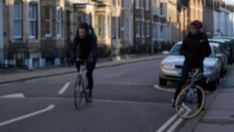 Defocused-Shot-of-Cyclist-Riding-Past-Another-Cyclist-