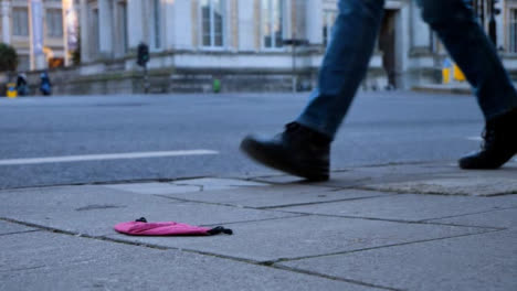 Low-Angle-Close-Up-Shot-of-Discarded-Face-Mask-On-Street