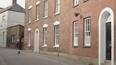 Tracking-Shot-of-Man-Walking-Past-Town-Houses