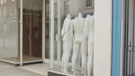 Tracking-Shot-Pulling-Away-from-Shop-Window-Full-of-Disused-Mannequins