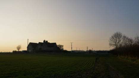 Kippschuss,-Der-Von-Einer-Pfütze-Aufschaut,-Um-Das-Bauernhaus-Bei-Sonnenuntergang-Zu-Enthüllen