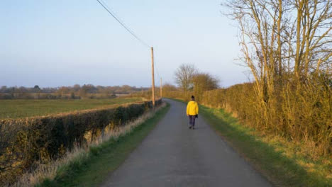 Tracking-Shot-Following-Person-Walking-Down-Countryside-Road