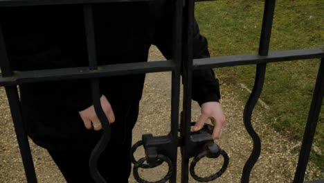 Close-Up-Shot-of-Womans-Hand-Opening-and-Closing-Iron-Gate-