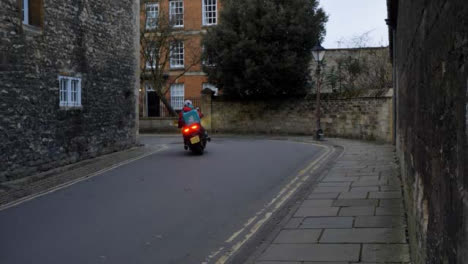 Tracking-Shot-Past-Wall-Revealing-Cyclist-and-Delivery-Scooter-