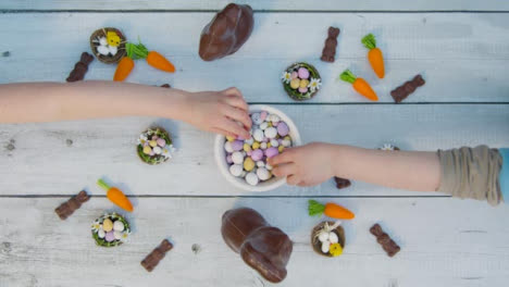 Overhead-Shot-of-Young-Children's-Hands-Taking-Chocolate-Eggs-from-a-Bowl