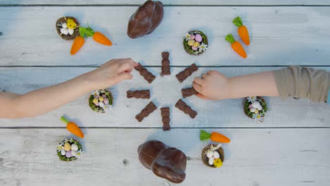 Overhead-Shot-of-Young-Children's-Hands-Taking-Small-Chocolate-Bunnies-from-Table