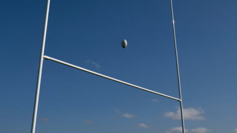 Low-Angle-Shot-Looking-Up-at-Rugby-Posts-as-Rugby-Ball-Flies-Over