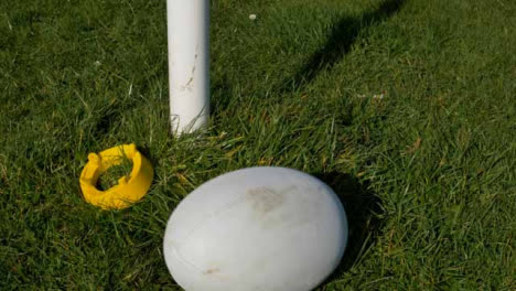 Nahaufnahme-Des-Rugbyballs,-Der-Neben-Dem-Abschlag-Und-Dem-Post-In-Den-Rahmen-Rollt