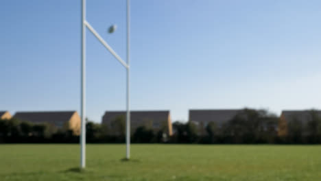 Defokussierte-Weitwinkelaufnahme-Des-Rugbyballs,-Der-Durch-Rugbypfosten-Fliegt
