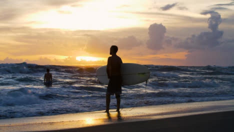 Wide-Shot-of-Surfer-Silhouetted-Against-Sunset