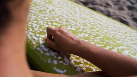 Handheld-Over-the-Shoulder-Shot-of-Person-Preparing-Surf-Board