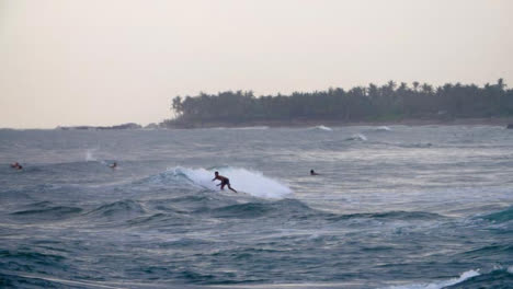 Handheld-Wide-Shot-of-Surfer-Riding-Waves-at-Pererenan-Beach