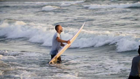Handheld-Song-Shot-Tracking-Surfer,-Der-In-Den-Ozean-Geht