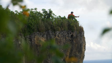 Long-Shot-of-Person-Standing-On-Cliff-Edge-at-Uluwatu-Coast