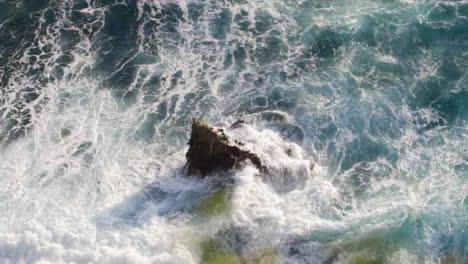 High-Angle-Shot-of-Waves-Crashing-Against-Rock-On-Uluwatu-Coast