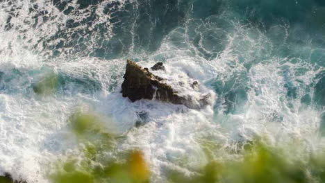 Hochwinkelaufnahme-Von-Wellen,-Die-Gegen-Einen-Felsen-An-Der-Küste-Von-Uluwatu-Krachen?