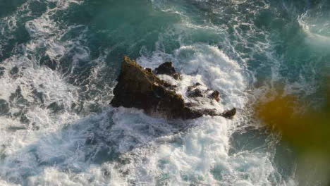 High-Angle-Shot-of-Waves-Crashing-Against-Rock-On-the-Uluwatu-Coast