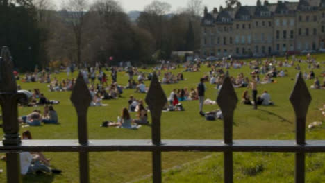 Tracking-Shot-Along-Railing-of-Busy-Royal-Crescent-Green