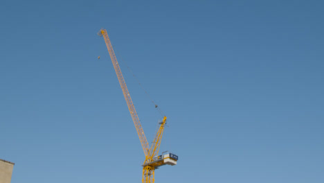Tracking-Shot-Looking-Up-at-Crane-at-Construction-Site