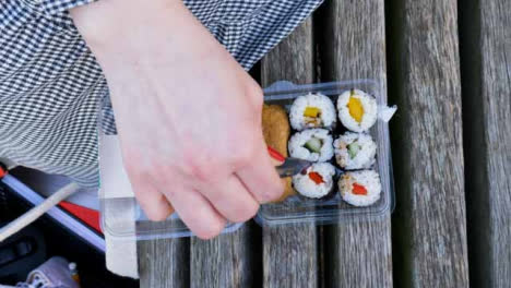 High-Angle-Shot-of-Female-Hands-Pouring-Sauce-On-Sushi