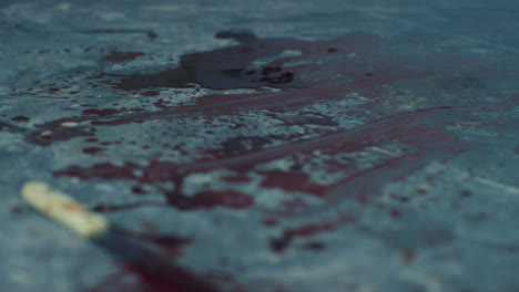 Sliding-Close-Up-Shot-of-Blood-On-Floor-of-Disused-Warehouse