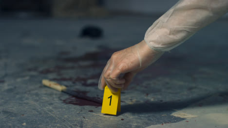 Sliding-Close-Up-of-Forensic-Placing-Evidence-Tag-Next-to-Bloody-Knife