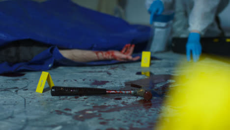 Sliding-Close-Up-of-Bloody-Hammer-with-Forensic-Placing-Evidence-Tag-In-Background-