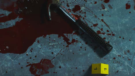 High-Angle-Shot-Looking-Down-at-a-Bloody-Hammer-at-Crime-Scene