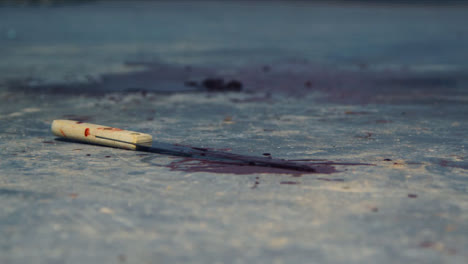 Close-Up-Shot-of-Bloody-Knife-at-Crime-Scene