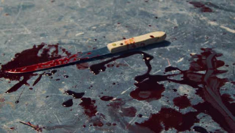 -Close-Up-Gimbal-Shot-of-Knife-and-Blood-at-Crime-Scene